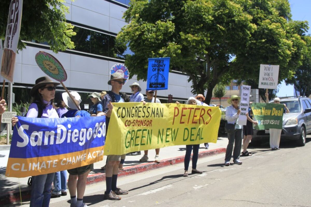 Activists protested outside U.S. Rep. Scott Peters office in San Diego’s University City neighborhood to persuade him to sign onto the Green New Deal on Friday, July 19, 2019. Environmental groups have been holding such events around the region since February.