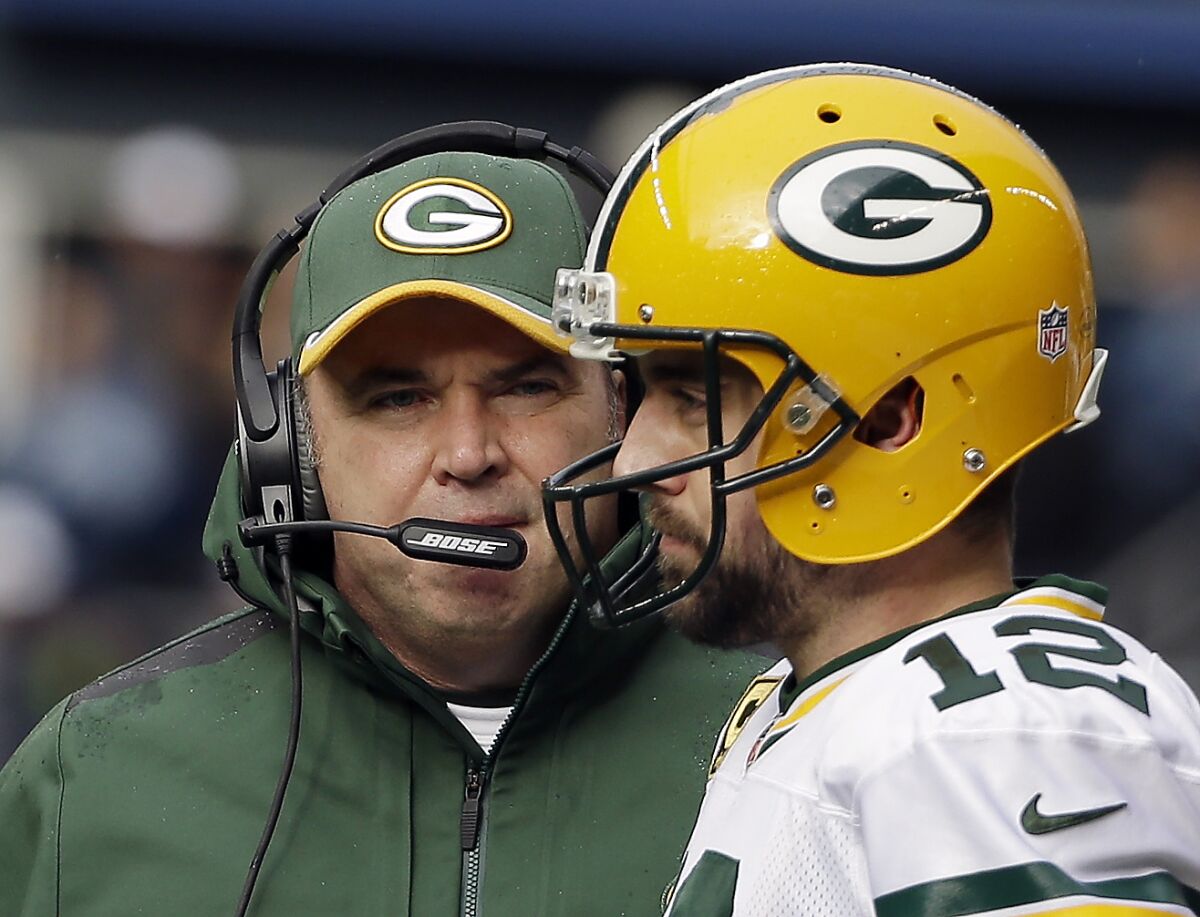 FILE - Green Bay Packers head coach Mike McCarthy talks to quarterback Aaron Rodgers (12) during the first half of the NFL football NFC Championship game against the Seattle Seahawks in Seattle, Jan. 18, 2015. The biggest offseason clue forecasting Aaron Rodgers’ eventual decision to stay in Green Bay came when Tom Clements ended his retirement to begin a second stint as the Packers’ quarterback coach. (AP Photo/David J. Phillip, File)