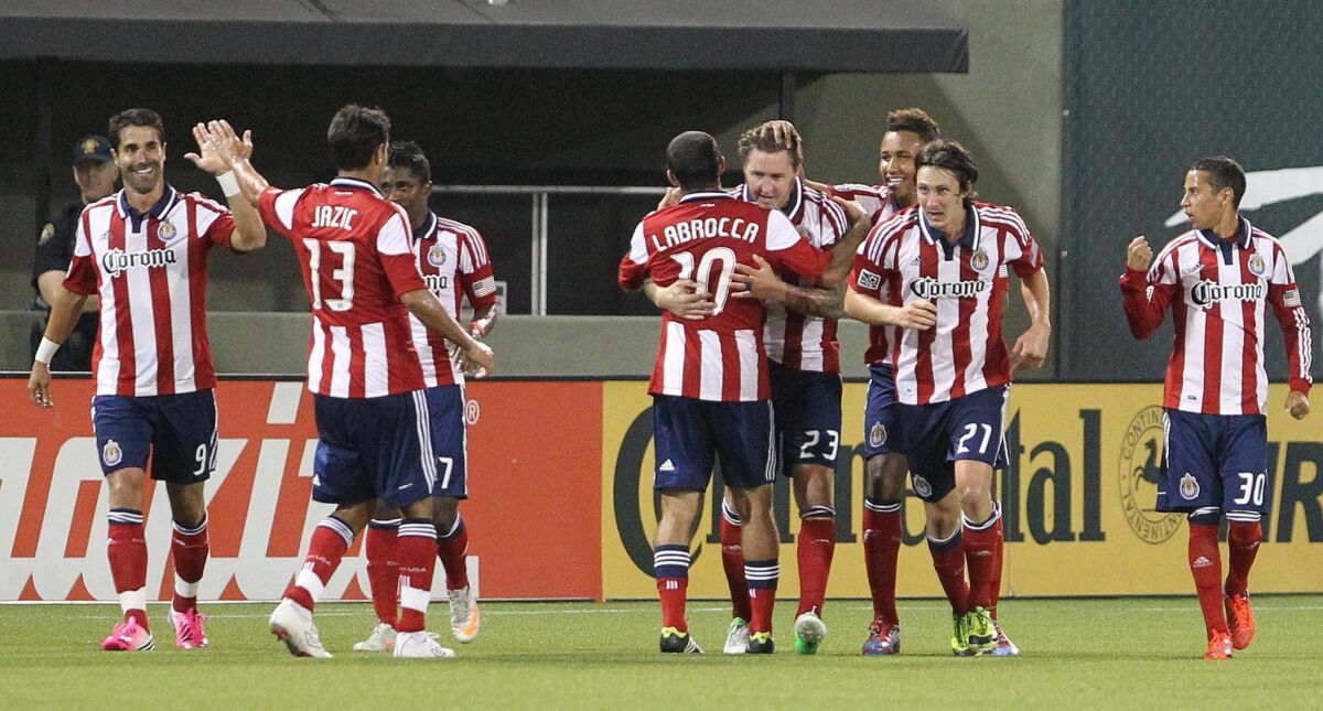 Chivas USA's Danny Califf (23) embraces teammate Nick LaBrocca (10) after he scores in the second half against the Portland Timbers in Portland, Ore., on July 28, 2012.