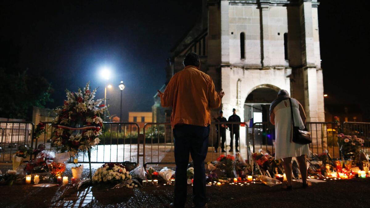 Mourners stands outside a church in Saint-Etienne-du-Rouvray after attackers killed an elderly priest.