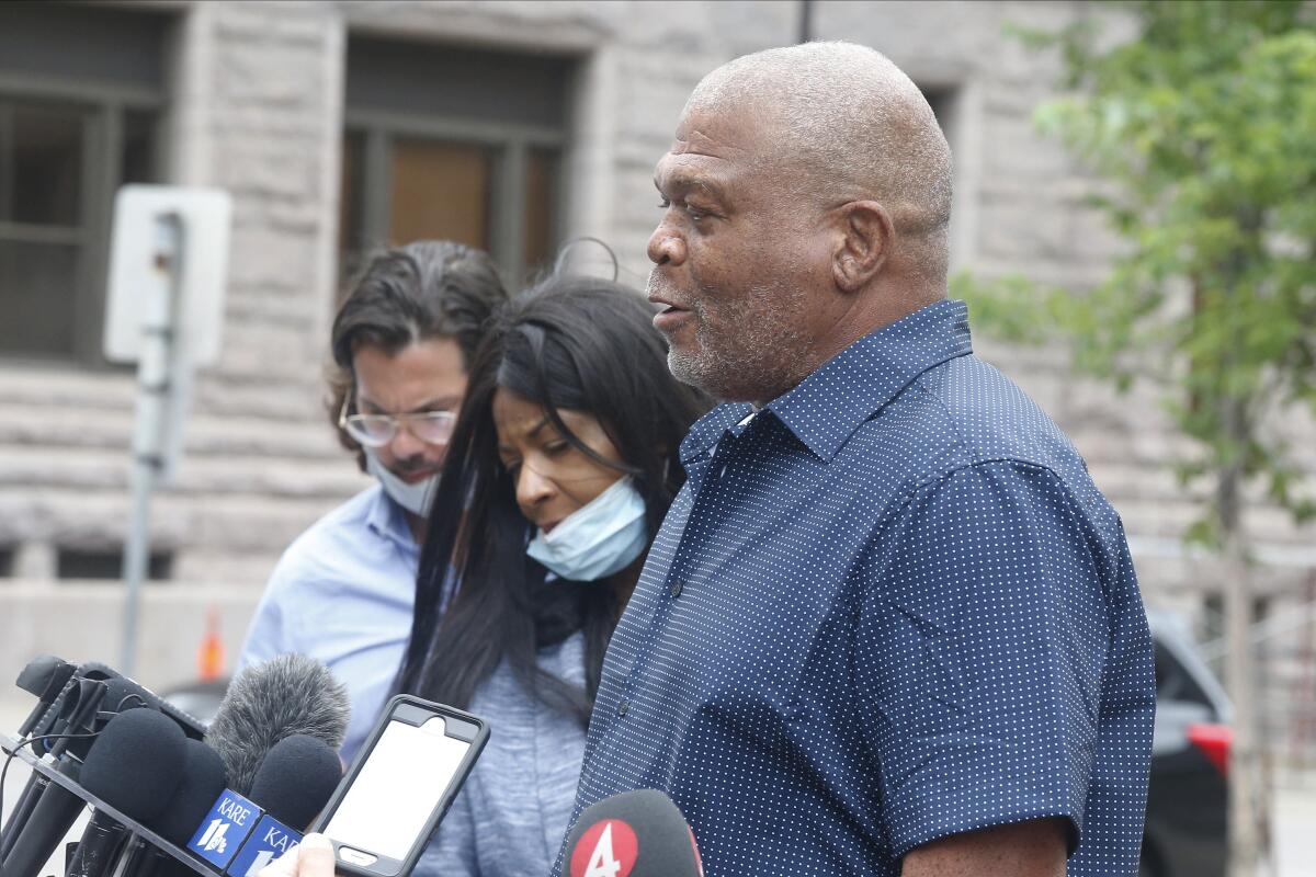 Five years after George Floyd's death, TV coverage of anniversary is subdued 3 A man in blue shirt stands near a set of microphones.