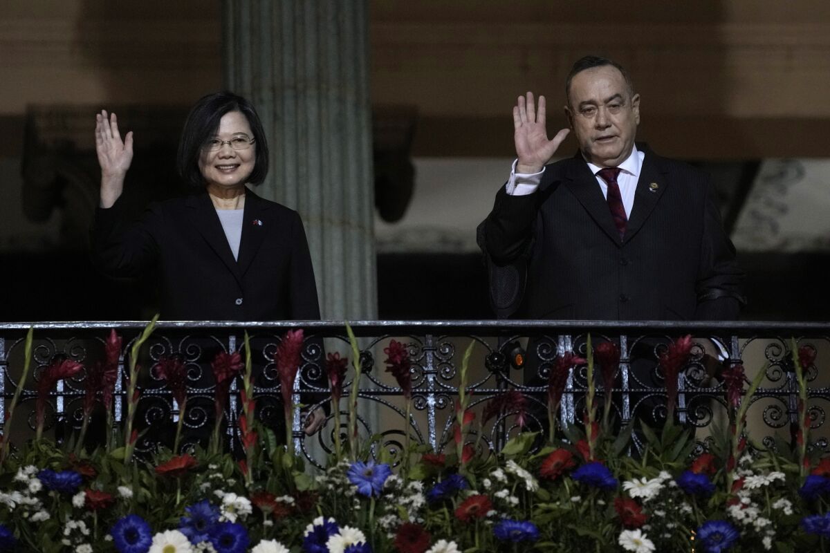 Taiwan's President Tsai Ing-wen, left, and Guatemala's President Alejandro Giammattei, wave from a balcony at the National Palace in Guatemala City, Friday, March 31, 2023. Tsai is in Guatemala for an official three-day visit. (AP Photo/Moises Castillo)