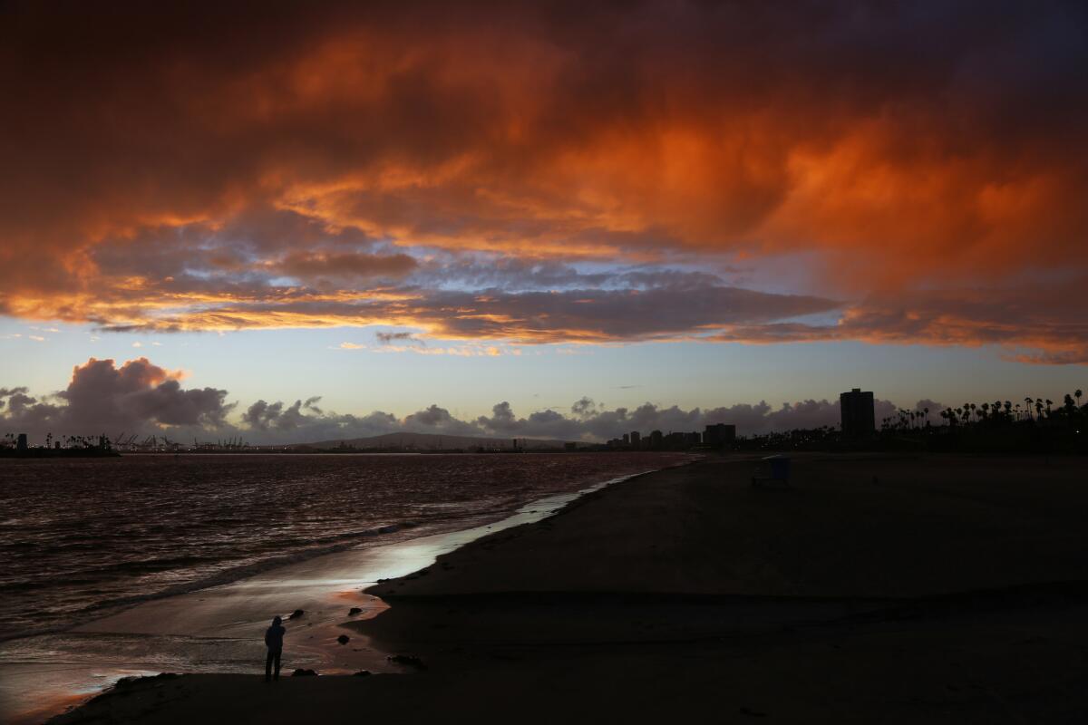 A man watches a memorable sunset ends a mostly rainy day in the Los Angeles area as the first big storm of El Niño rolled through the area.