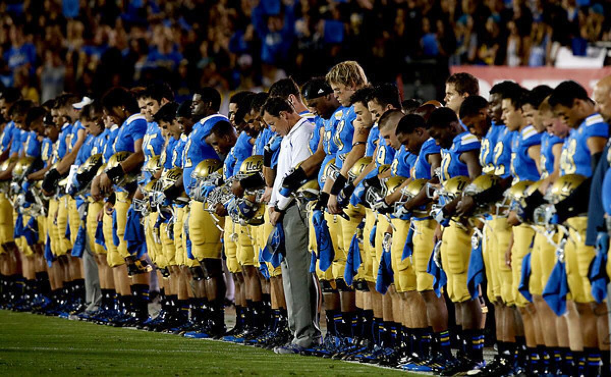 Coach Jim Mora and the UCLA football team observes a moment of silence in memory of teammate Nick Pasquale before the start of a Sept. 21 game against New Mexico State. Mora hasn't let his obligations as a college football coach hinder him from helping Pasquale's family.