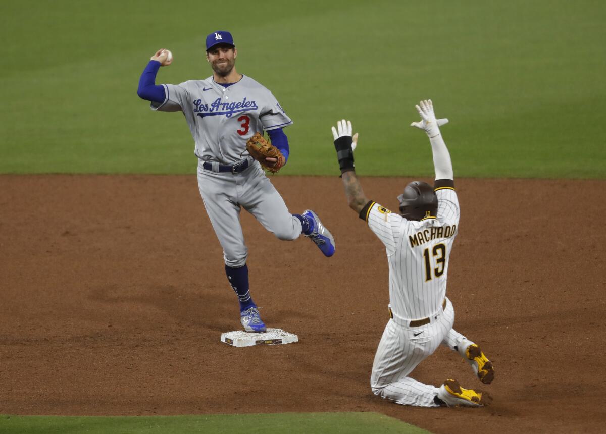 Dodgers second baseman Chris Taylor makes an unassisted double play in front of San Diego Padres baserunner Manny Machado.