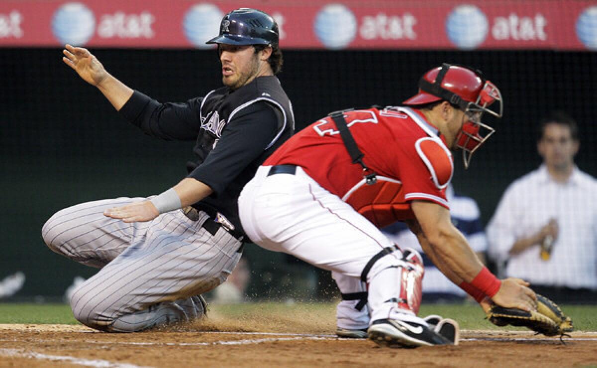 Colorado's Ian Stewart, left, scores a run past Angels catcher Mike Napoli during a game in 2009. Stewart has signed a minor-league contract with the Angels.