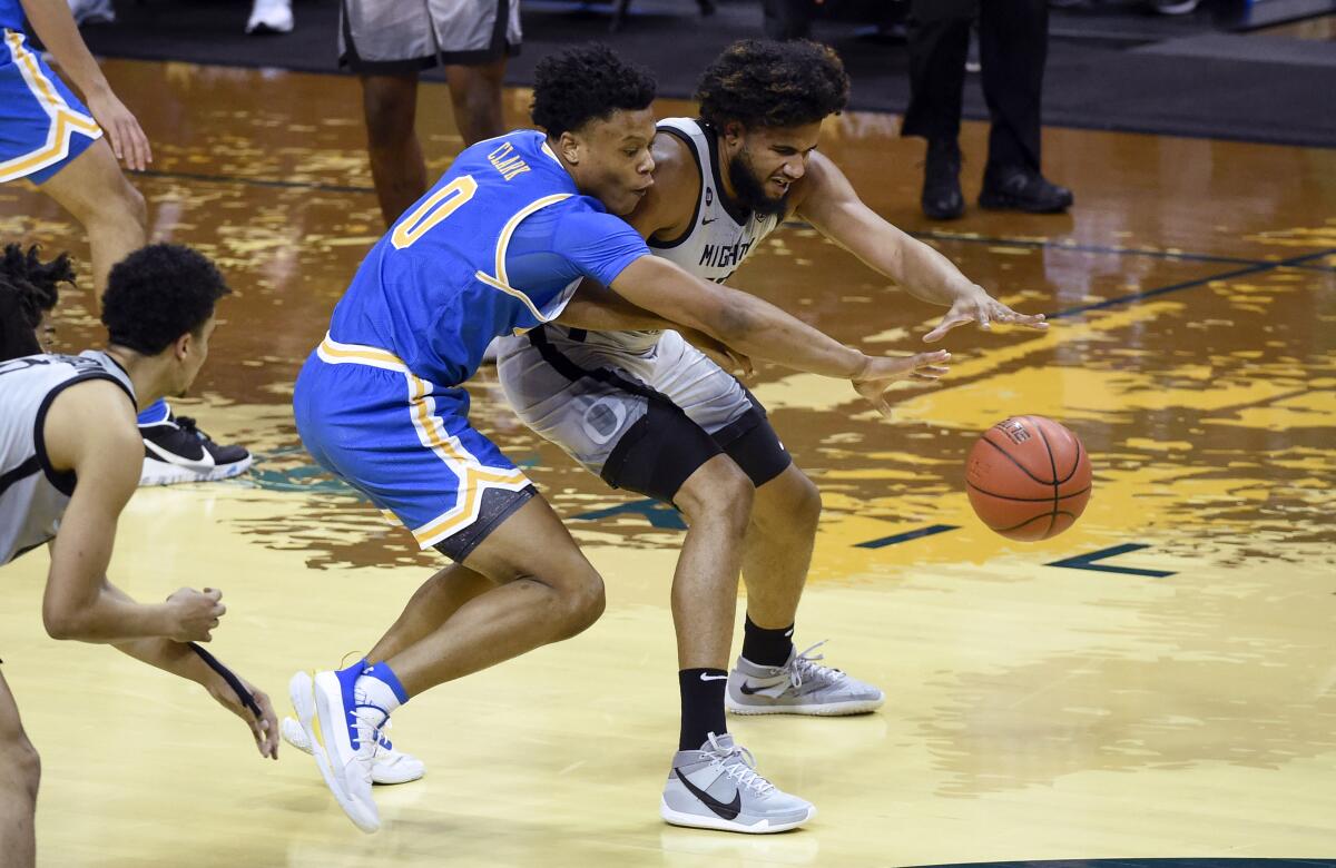 UCLA guard Jaylen Clark, left, tries to steal the ball from Oregon guard LJ Figueroa during the first half Wednesday.