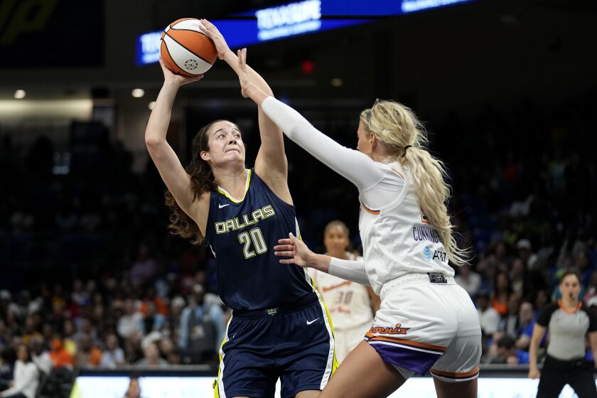 Dallas Wings forward Maddy Siegrist (20) looks to shoot against Phoenix Mercury's Sophie Cunningham during the first half of a WNBA basketball game Wednesday, June 7, 2023, in Arlington, Texas. (AP Photo/Tony Gutierrez)