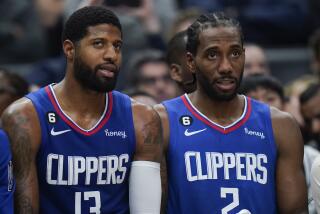 Los Angeles Clippers' Paul George and Kawhi Leonard watch from the bench