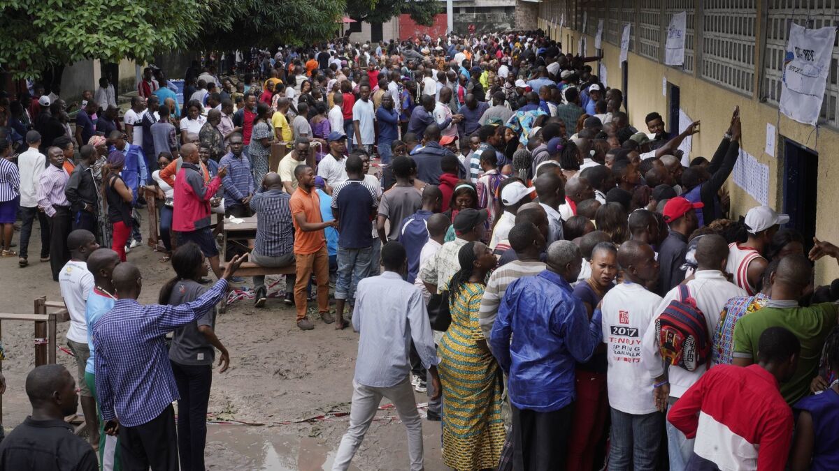 Hundreds of Congolese waiting at a school in Kinshasa's Limete district storm polling stations on Dec. 30, 2018, after voter listings were finally posted five hours after the official start of balloting.