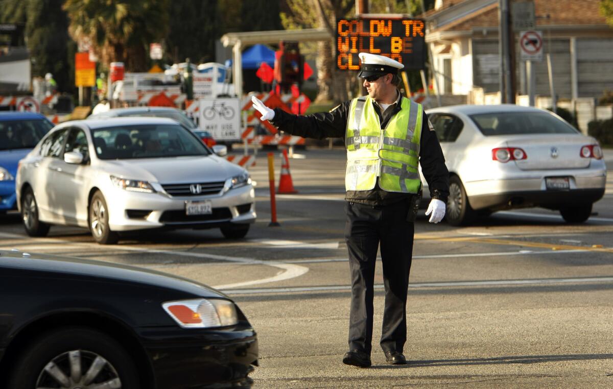 A Los Angeles Department of Transportation traffic officer directs traffic at the intersection of Coldwater Canyon Avenue and Ventura Boulevard in Studio City.