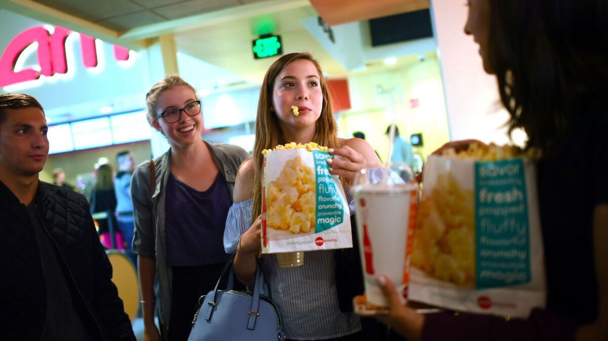 Friends Max Dodd, left, Morgan Gerlach, Natalie Gold and Audrey Hattori grab popcorn before a screening of "Baywatch" in Santa Monica. (Christina House / For The Times)