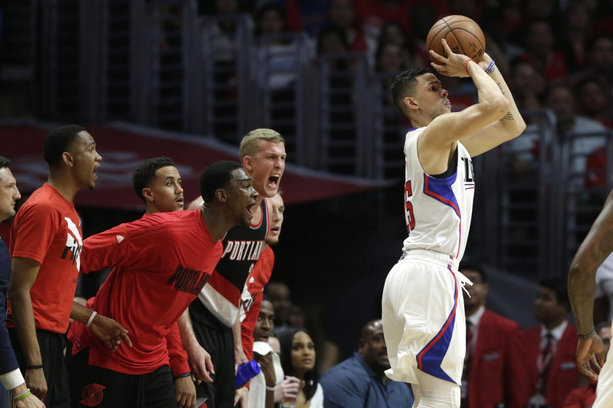Clippers guard Austin Rivers takes a three pointer and misses as Trail Blazers bench players try to distract him during the second half of Game 2.
