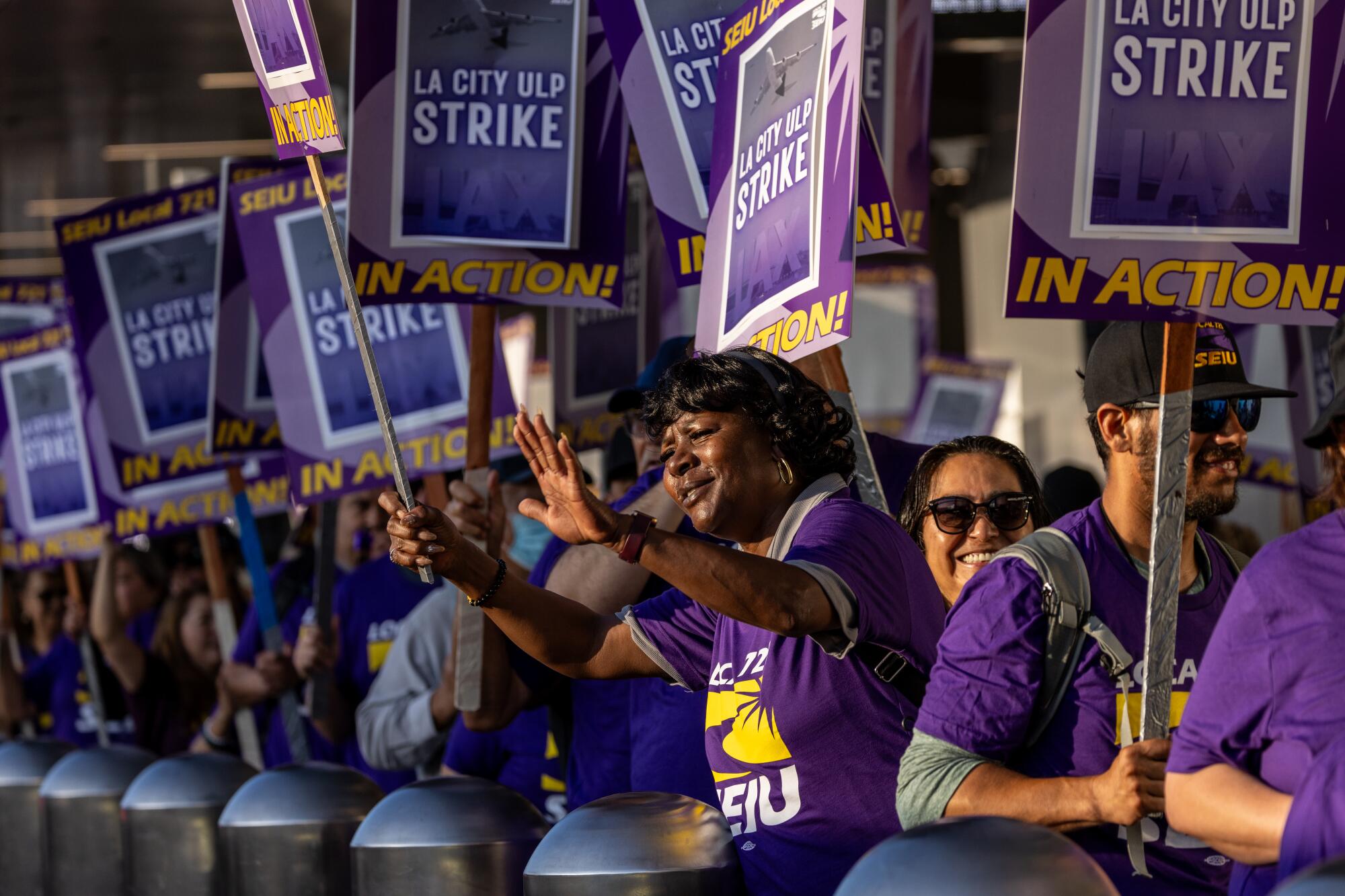 A woman urges motorists to honk during a strike by Los Angeles city workers.