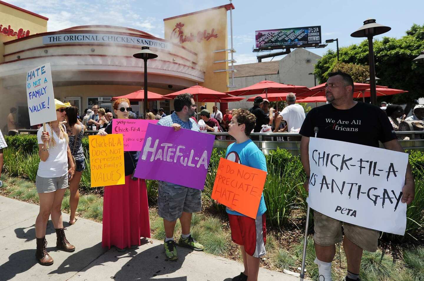 Anti Chick-fil-A protesters hold signs outside a restaurant in Hollywood.