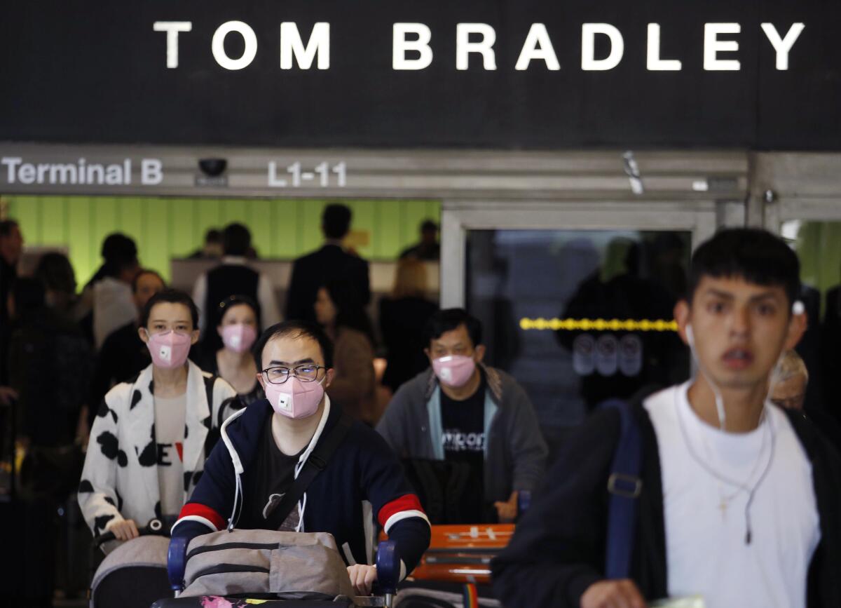 Travelers arrive at the Tom Bradley International Terminal at Los Angeles International Airport in Los Angeles on Feb. 8.