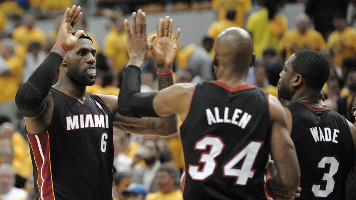 Miami Heat forward LeBron James, left, high-fives teammates Ray Allen, center, and Dwyane Wade following their 87-83 victory over the Indiana Pacers in Game 2 of the NBA Eastern Conference finals Tuesday.