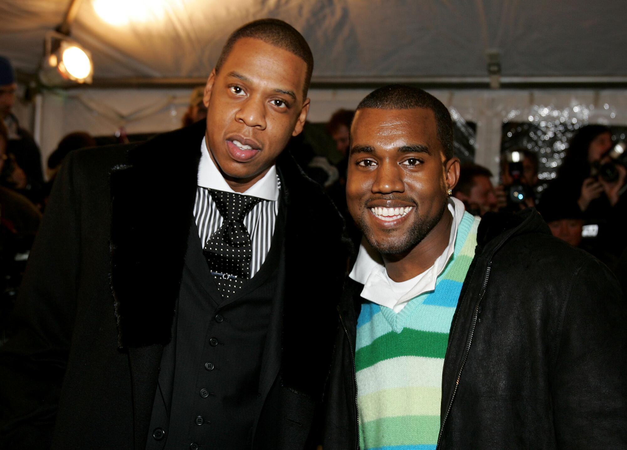 Two rap stars stand side by side for a photo.