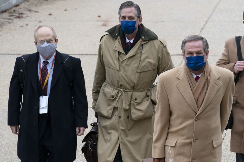 Attorneys walk outside in coats and masks