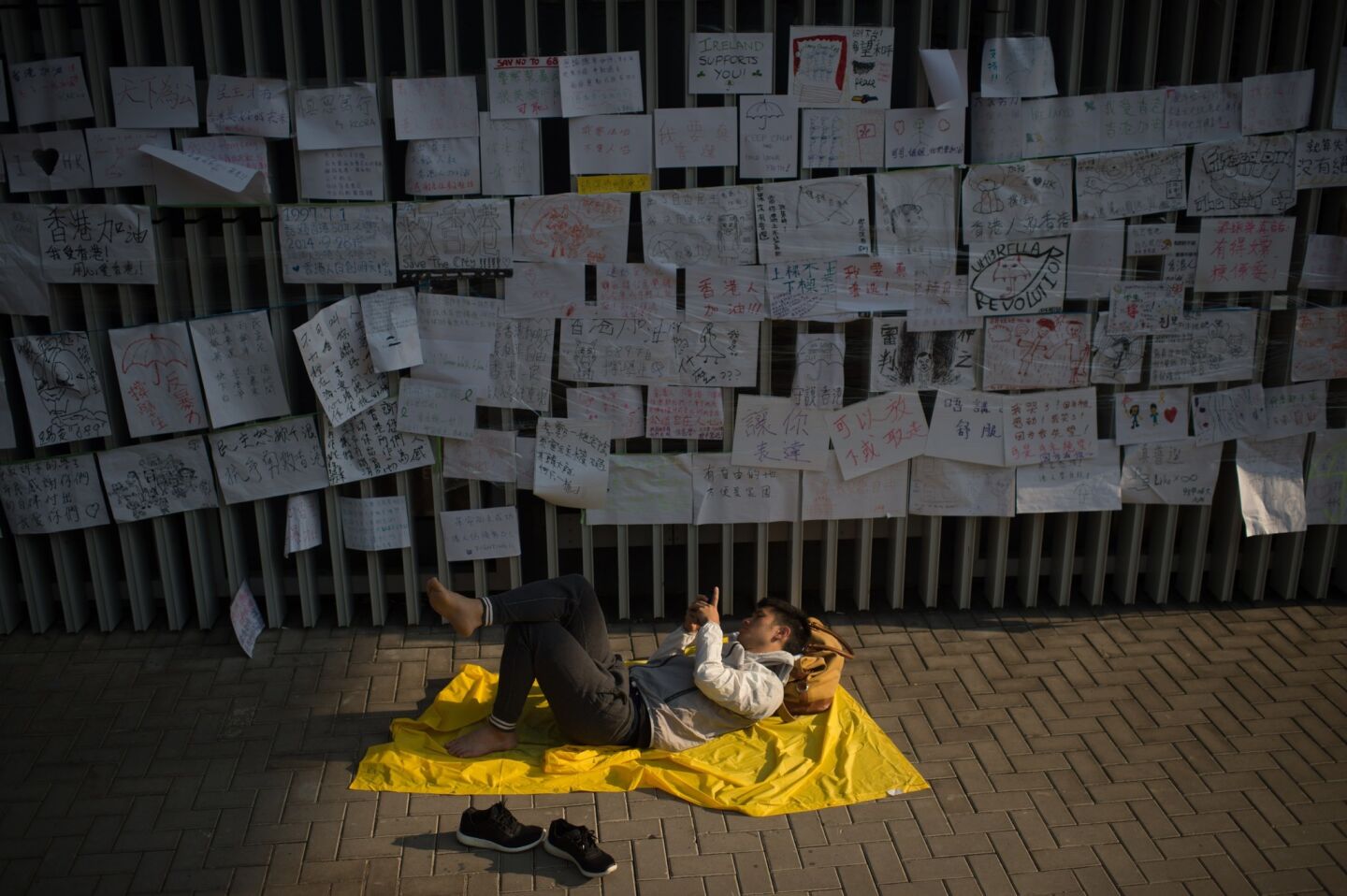 A pro-democracy protester sleeps beneath messages of support in the Admiralty district of Hong Kong on Oct. 7.