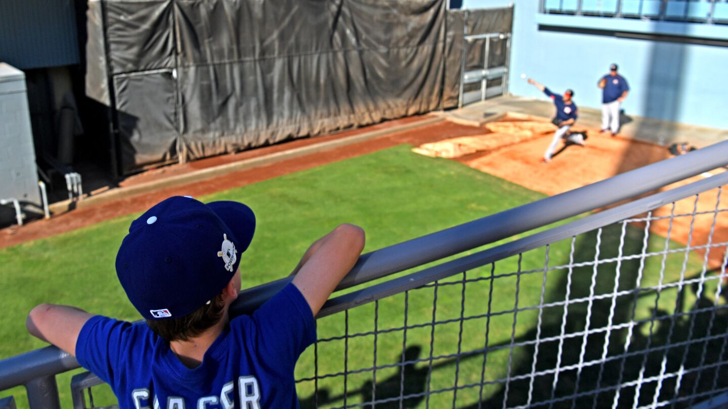 A Corey Seager fan watches an Astros pitcher work out in the bullpen before Game 2.