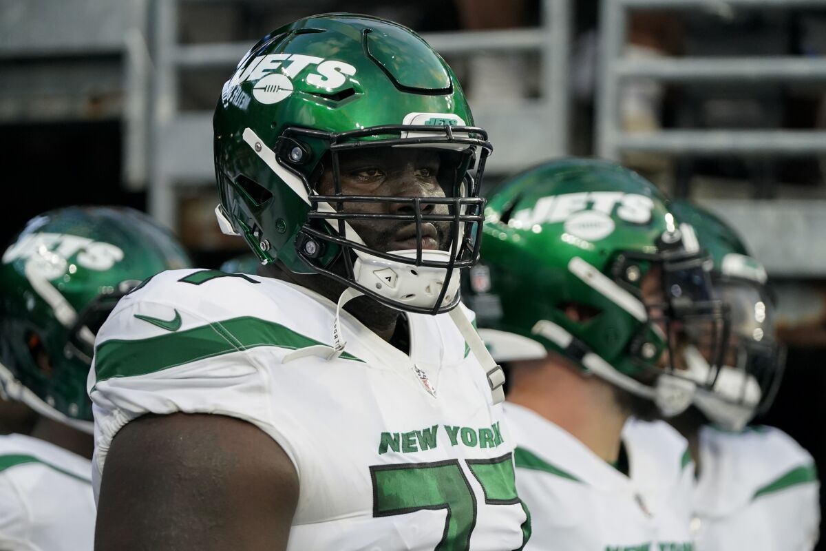 FILE - New York Jets offensive tackle Mekhi Becton waits to take the field before an NFL preseason football game against the New York Giants, Saturday, Aug. 14, 2021, in East Rutherford, N.J. New York Jets offensive tackle Mekhi Becton joined his teammates for the start of mandatory minicamp after he skipped the voluntary offseason program. (AP Photo/Frank Franklin II, File)