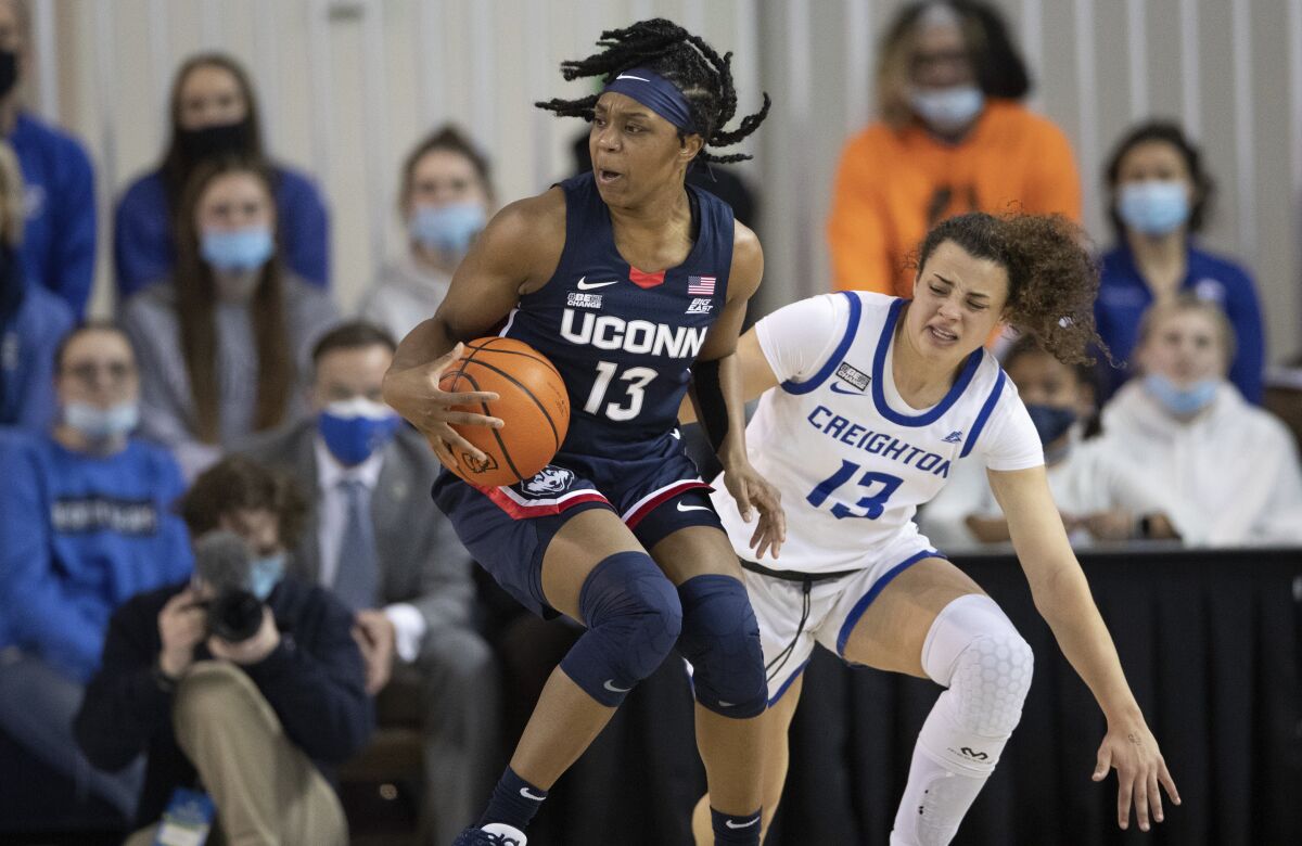 Connecticut's Christyn Williams (13) plays against Creighton's Rachael Saunders (13) during the first half of an NCAA college basketball game Wednesday, Feb. 2, 2022, in Omaha, Neb. (AP Photo/Rebecca S. Gratz)