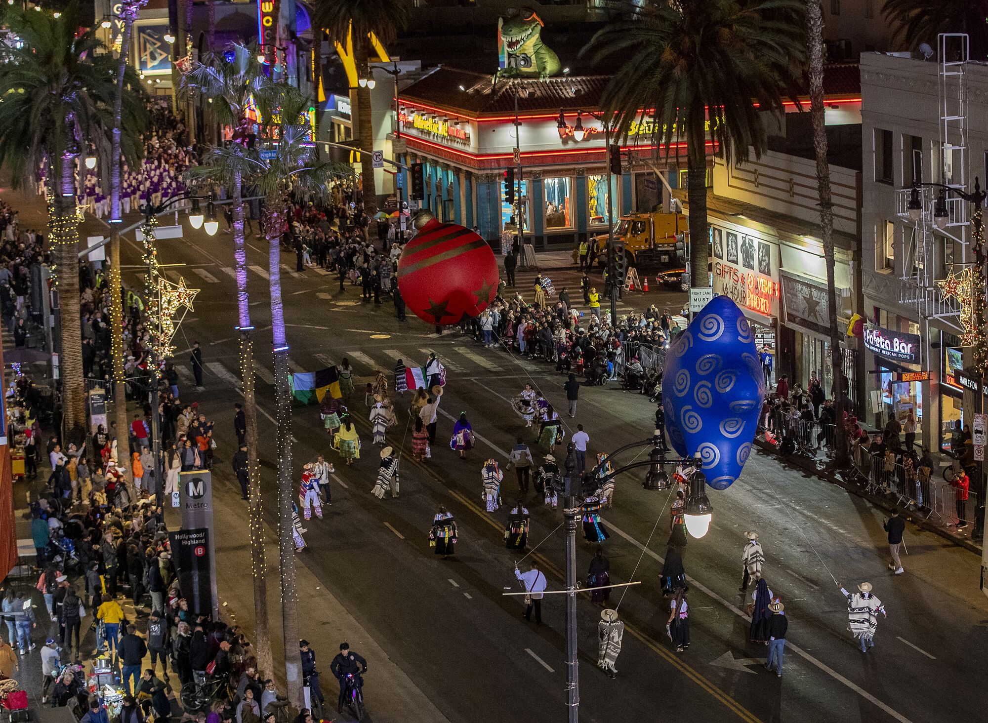 People line Hollywood Boulevard to watch people walk with giant red and blue balloons during the parade.