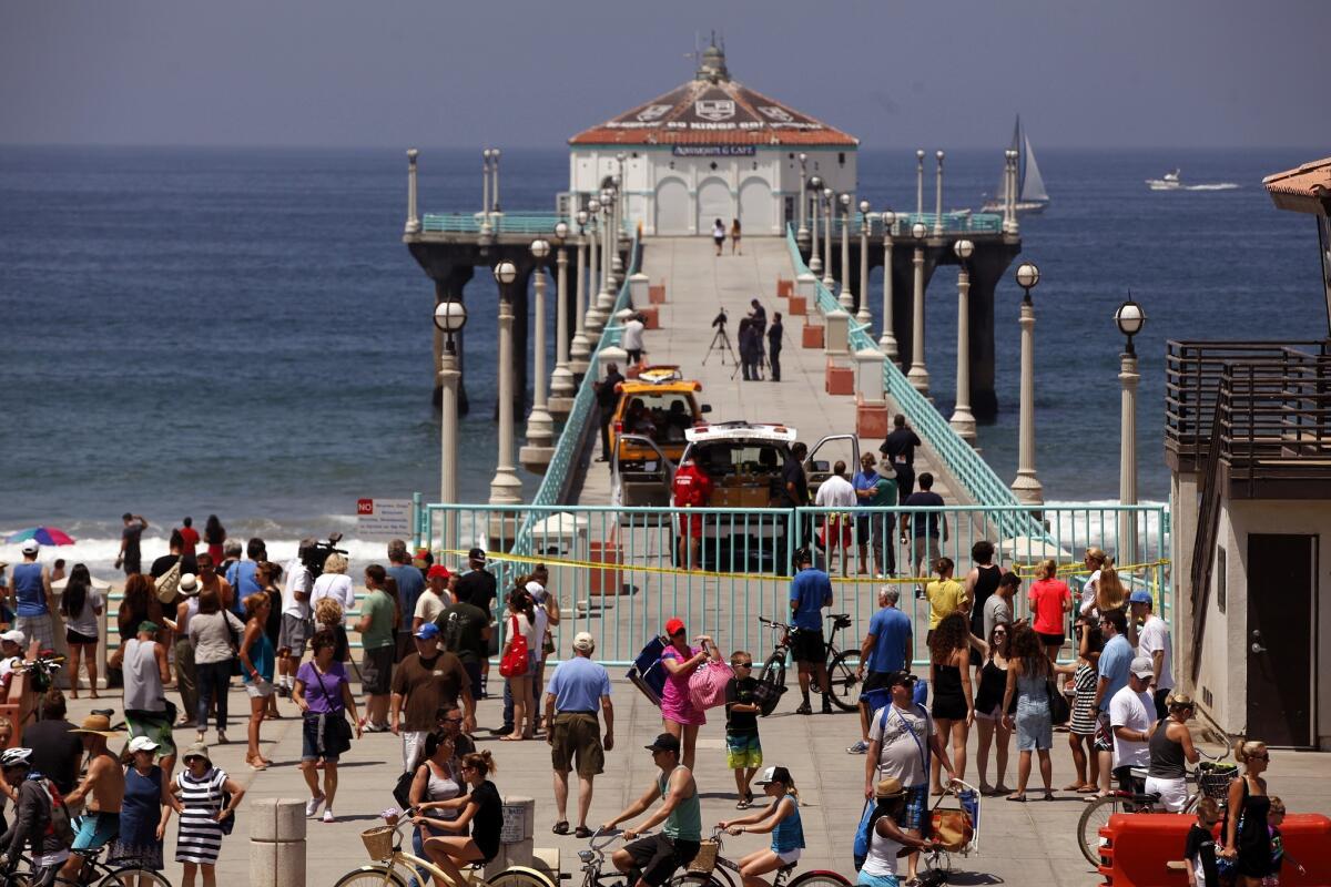 The Manhattan Beach pier was closed off on Saturday morning after a shark attack occurred in the waters nearby. The waters were also closed to swimmers on a busy Saturday. The injured swimmer was taken to an area hospital. Lifeguards patrolled the beach on foot reminding beachgoers to stay out of the water while a boat patrolled close to shore.