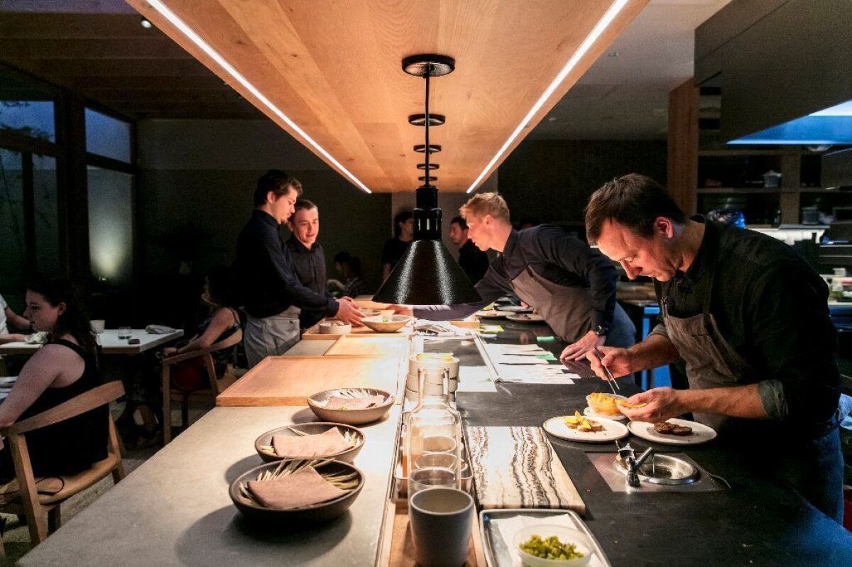 Auburn chef-owner Eric Bost, right, finishes plating a dish during dinner service.