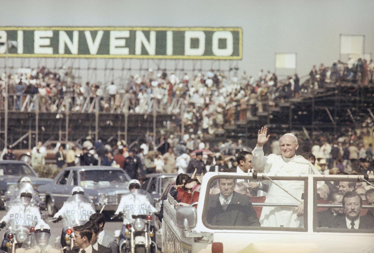 El papa Juan Pablo II saluda a los fieles durante un recorrido por la Ciudad de México el 25 de enero de 1979. Juan Pablo visitó cinco veces el país y conquistó los corazones de los mexicanos, que ahora se aprestan a recibir a Francisco, un pontífice más liberal y que habla con mucha franqueza de los problemas mundiales. (AP Photo, File)