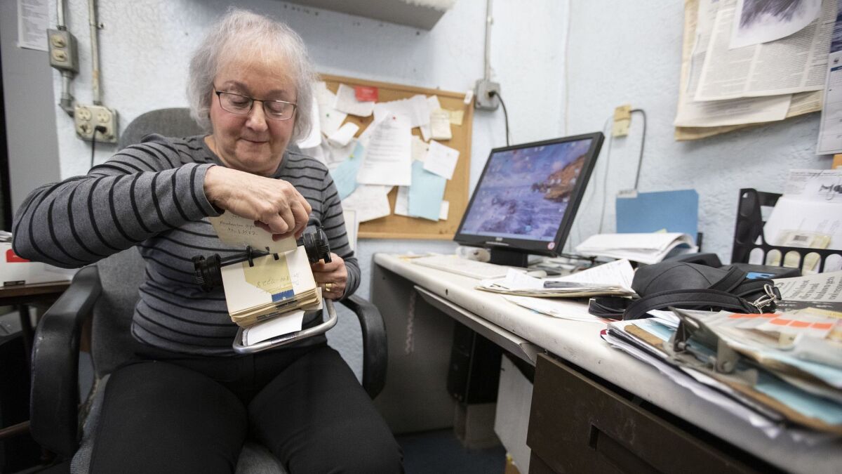 Karen Mason looks through her Rolodex at Circus of Books, which she and husband Barry are closing after nearly four decades in West Hollywood.