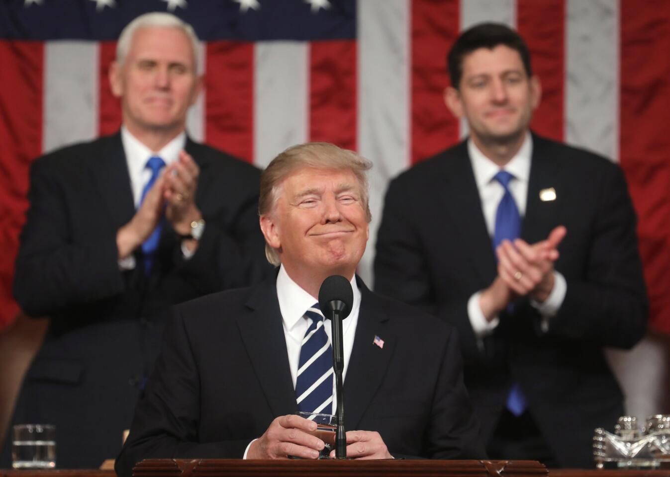 President Donald Trump delivers a speech before Congress as Vice President Mike Pence and House Speaker Paul Ryan applaud Feb. 28, 2017.