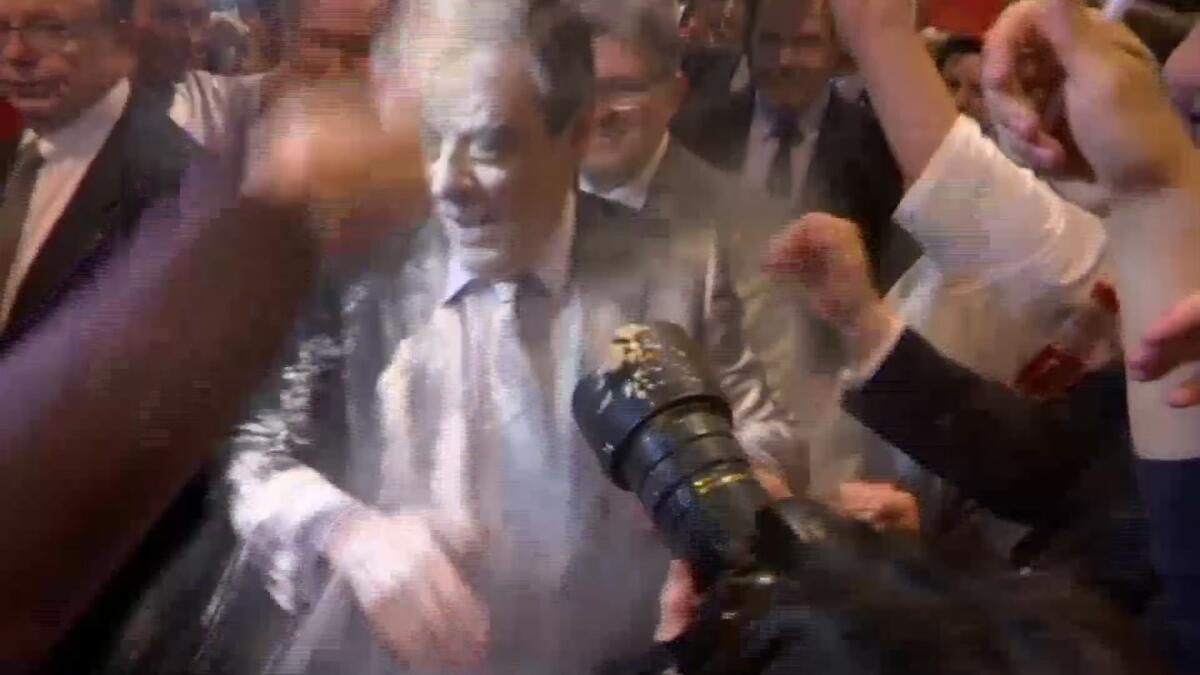 Conservative French presidential candidate Francois Fillon is doused with flour as he arrives at a political meeting in the eastern city of Strasbourg on Thursday.