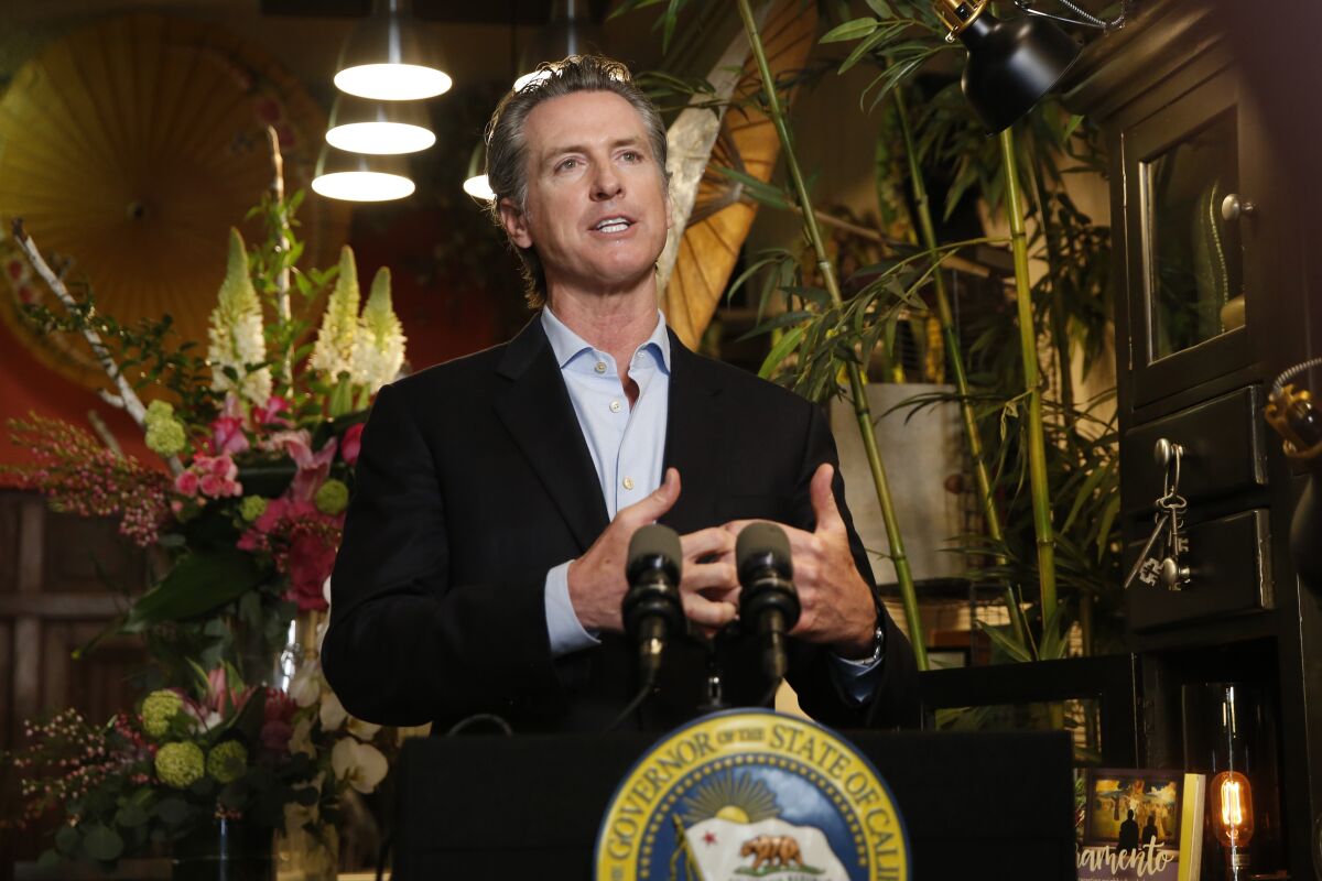 Gov. Gavin Newsom discusses the reopening of businesses during a news conference at Twiggs Floral Design Gallery in Sacramento on Friday.