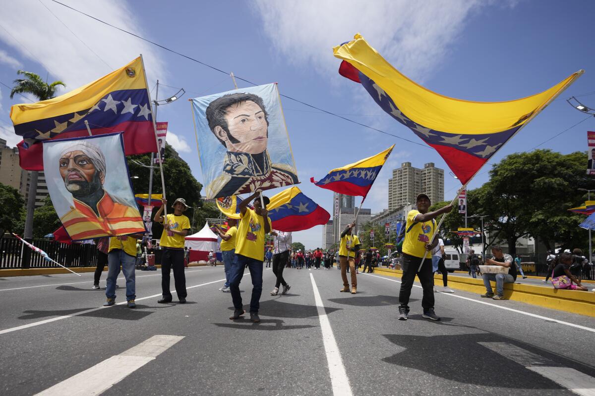 Simpatizantes del presidente venezolano, Nicolás Maduro, ondean banderas nacionales y carteles 