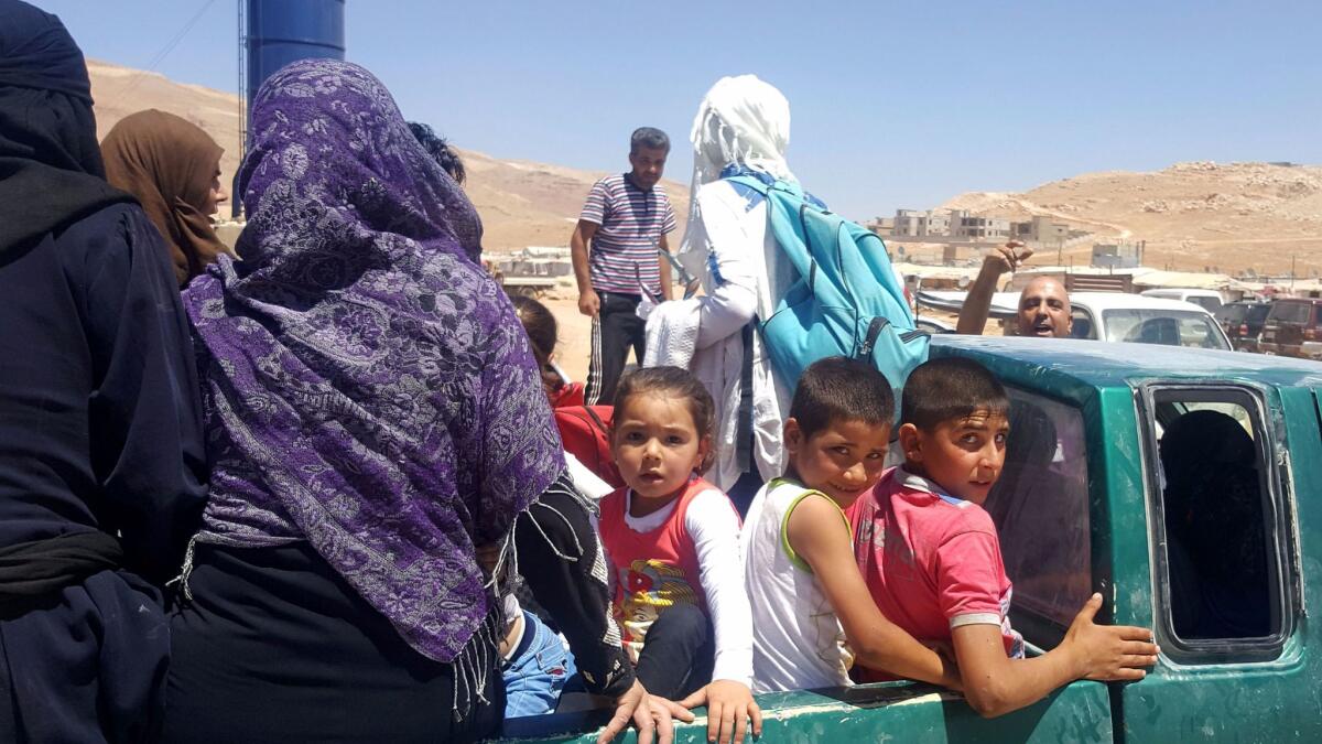 Syrian refugees arrive Aug. 2 in Wadi Hamayyed, on the outskirts of Lebanon's northeastern border town of Arsal, to board buses bound for the northwestern Syrian town of Idlib.