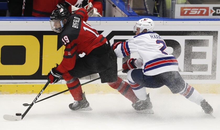 Jordan Harris of the U.S., right, chases Canada's Quinton Byfield on the ice during the world junior championships Dec. 26.