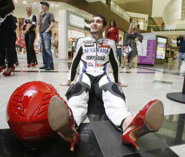 Tommy Aquino, of Saugus, with Graves Motorsports Yamaha, sits on the floor to get comfortable in the high heels he was wearing at the Glendale Galleria for the first Go Red for Women Stiletto Strut, hosted by the American Heart Association and Macy's on Thursday, February 3, 2011 in Glendale. About 50 women and three men wore heels of varying heights to support research for heart disease which is the number one killer of women.