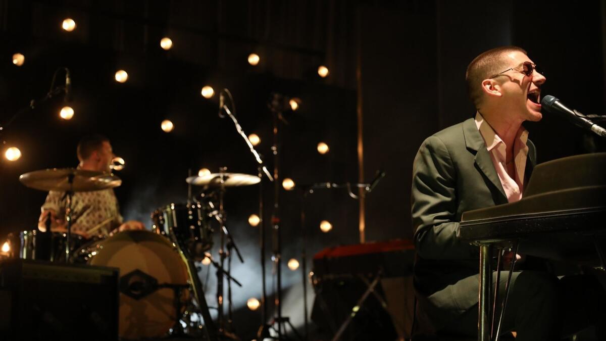 Alex Turner sings with drummer Matt Helders as Arctic Monkeys performs at the Hollywood Bowl on Tuesday..