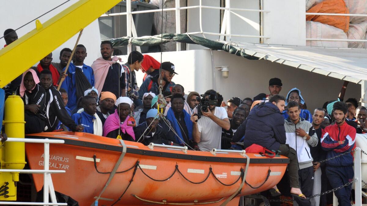 Migrants wait to disembark after a rescue operation at sea on Oct. 13 in Palermo, Sicily.