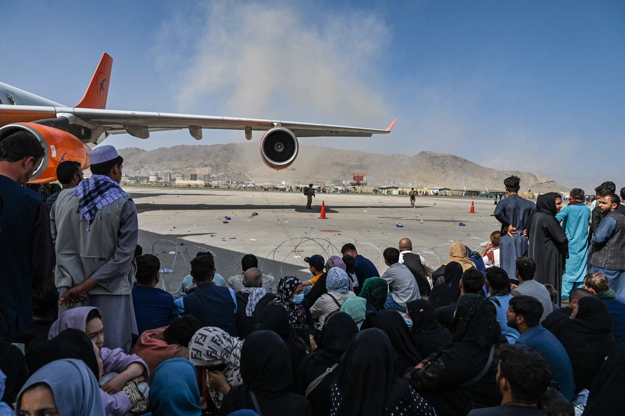People sit at the Kabul airport.