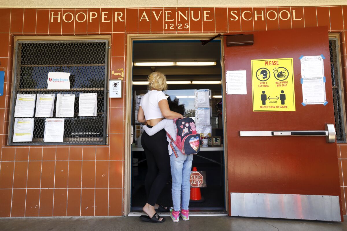 Carsha Shifflet at the entrance to Hooper Avenue Elementary with Zadie Williams, 8.