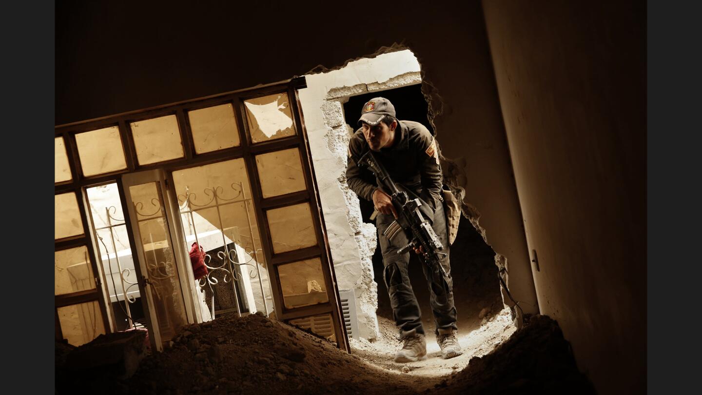 Waleed Abdel Nabi, 28, clears what appear to be abandoned homes in the advance toward Mosul.