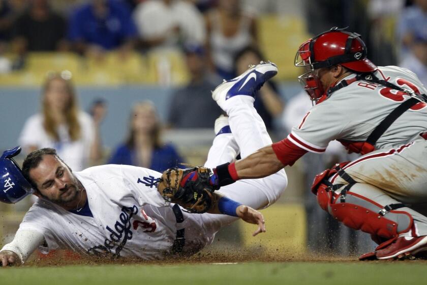 Dodgers outfielder Scott Van Slyke, left, is tagged out by Philadelphia Phillies catcher Carlos Ruiz during a game in June.