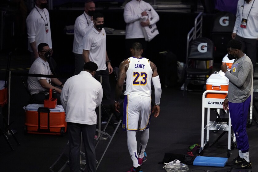 Lakers forward LeBron James walks off the court after his right ankle was injured.