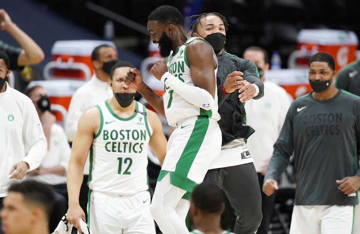 Boston Celtics guard Jaylen Brown, front left, celebrates with guard Carsen Edwards late in the second half of an NBA basketball game against the Denver Nuggets, Sunday, April 11, 2021, in Denver. (AP Photo/David Zalubowski)