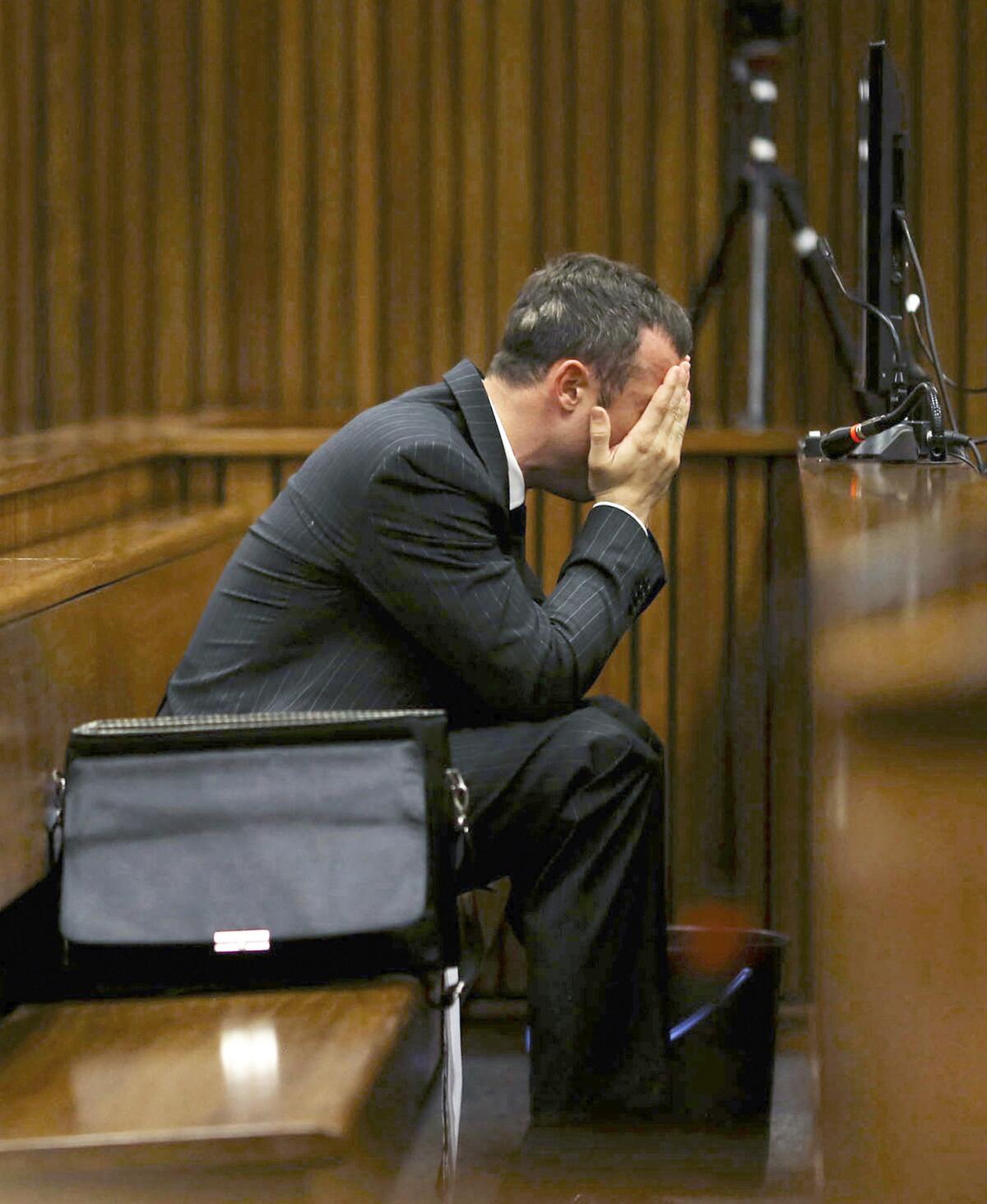 Oscar Pistorius covers his head in a Pretoria court on Monday as he listens to questioning about the events surrounding the shooting death of his girlfriend, Reeva Steenkamp.