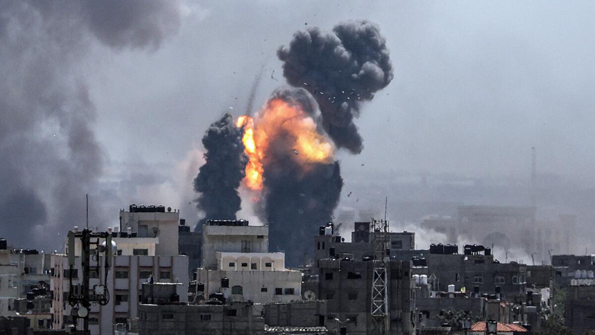 Smoke and flames rise from buildings Saturday after an Israeli airstrike on Gaza City.