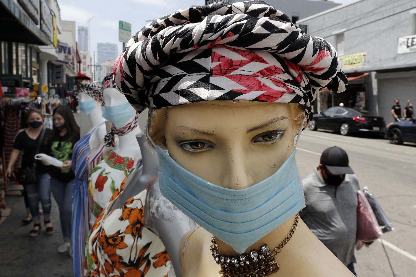 Shoppers and mannequins wear protective masks in the Los Angeles downtown garment district on Thursday.